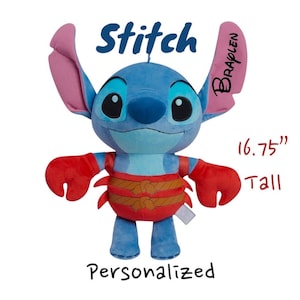May include: A blue plush Stitch doll, approximately 16.75 inches tall, with large ears and red accents on the arms and waist. The word "Stitch" is written above the doll, and "Personalized" is written below.