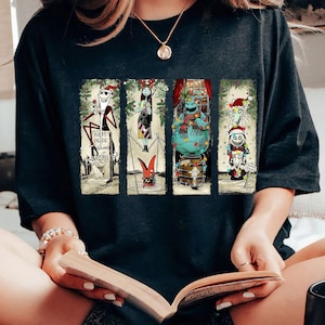 Può includere: T-shirt nera con quattro pannelli rettangolari con personaggi di Nightmare Before Christmas. Jack Skellington, Sally e altri personaggi sono raffigurati con abiti festivi. Il testo "REST PEACE ZERO" è visibile su un pannello.