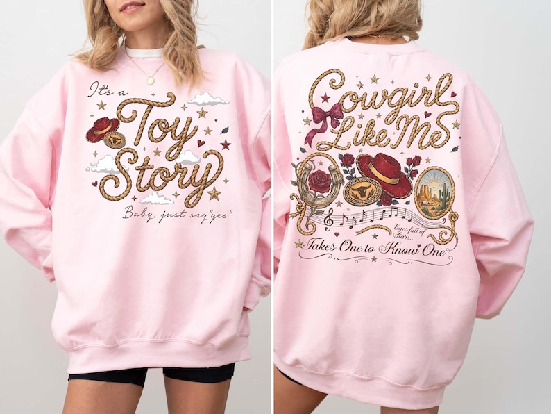 Pu&ograve; includere: Una felpa girocollo rosa chiaro con una stampa grafica sul davanti e sul retro. Il davanti mostra il testo It's a Toy Story Baby, just say yes con un carattere a corda, un cappello rosso e stelle. Il retro mostra Cowgirl Like Me con un cappello rosso, rose, un ferro di cavallo e note musicali.