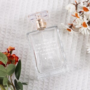 May include: A clear glass perfume bottle with a gold cap and a handwritten message on the bottle that reads: "Mom, All that I am and all that I hope to be I owe to you. Thank you for being by my side Today and always. Emily"