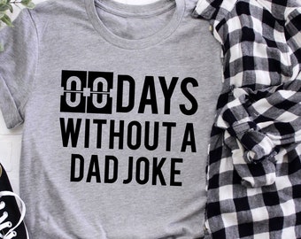 Könnte beinhalten: Ein graues T-Shirt mit schwarzem Text, der "00 TAGE OHNE EINEN VATERWITZ" lautet.