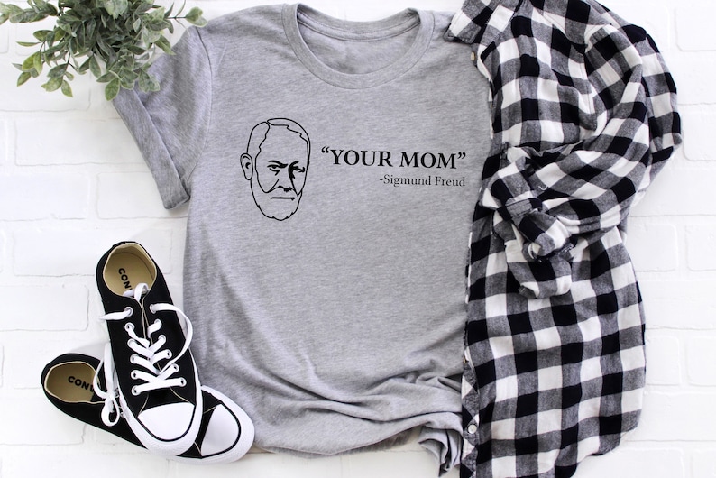 May include: A grey t-shirt with a black outline of a man's face and the text "YOUR MOM" -Sigmund Freud.