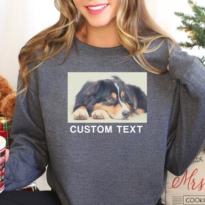 Op de afbeelding: Een grijs sweatshirt met een foto van een hond op de voorkant. De tekst "CUSTOM TEXT" is onder de foto gedrukt.