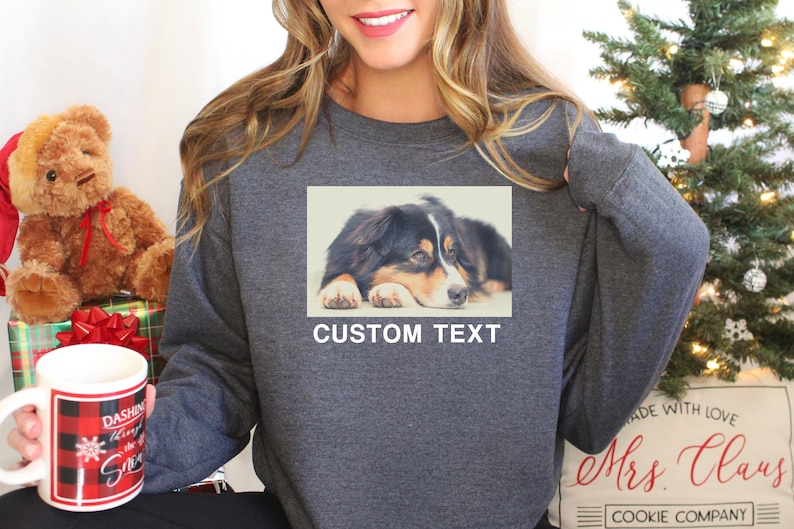 Op de afbeelding: Een grijs sweatshirt met een foto van een hond op de voorkant. De tekst "CUSTOM TEXT" is onder de foto gedrukt.
