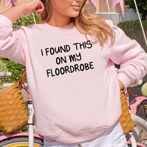May include: Pink sweatshirt with the text "I found this on my floordrobe" printed on the front.