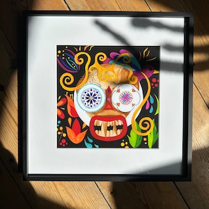 Könnte beinhalten: Ein gerahmter Druck eines farbenfrohen, stilisierten Schädels mit komplizierten Details. Der Schädel hat große, runde Augen mit bunten Mustern und ein breites, zahniges Grinsen. Der Hintergrund ist schwarz mit Farbspritzern und wirbelnden Mustern.
