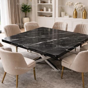 Op de afbeelding: Een moderne eethoek met een vierkante zwarte marmeren tafel met witte adering, ondersteund door een zilveren metalen voet. Acht beige gestoffeerde stoelen met goudkleurige poten omringen de tafel.