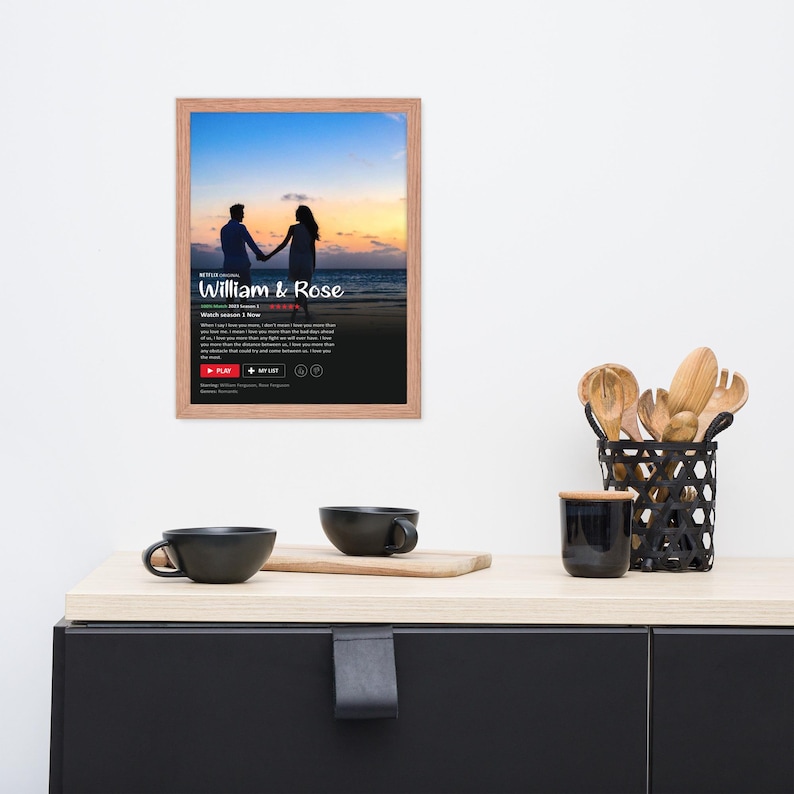 May include: A framed poster with a black background and a couple silhouetted on a beach at sunset. The poster has the text "NETFLIX ORIGINAL William & Rose" and "Watch Season 1 Now" with a play button and other icons.