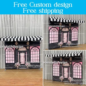 May include: A black and white striped canopy tops a pink and black booth with arched windows and a door. The booth has the text "Free Custom design Free shipping" at the top. The booth is decorated with floral arrangements.
