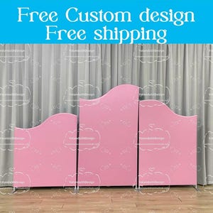 May include: Three pink curved backdrop panels for a photo booth or event. The panels are made of foam board and are free standing. The panels are in front of a white curtain.