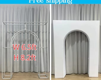 May include: Two wedding arch backdrops, one made of metal and the other made of white foam. The metal arch is 6.5 feet wide and 8.2 feet tall. Both arches have a rounded top.