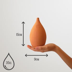 May include: Terracotta oil dispenser with a capacity of 35cl. The dispenser is 15cm tall and 9cm wide. It has a rounded, teardrop shape and a small opening at the top.