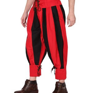 May include: Red and black striped pants with a gathered waist and lace-up cuffs. The pants are cropped and have a loose fit.