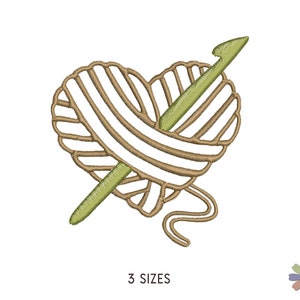 May include: A brown and white yarn ball in the shape of a heart with a green crochet hook sticking out of it.
