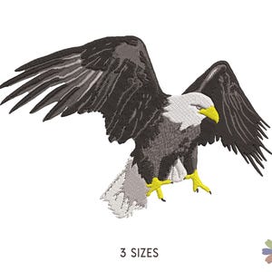 May include: A black and white embroidered design of a bald eagle with its wings spread. The eagle is in flight and has a yellow beak and talons.