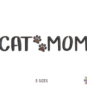 May include: Black embroidery design of the text "CAT MOM" with two brown paw prints between the words.