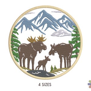 May include: Embroidered patch featuring a family of moose in a mountain landscape. The patch is circular and has a beige background with green trees, blue mountains, and white clouds. The moose are brown and have white antlers.