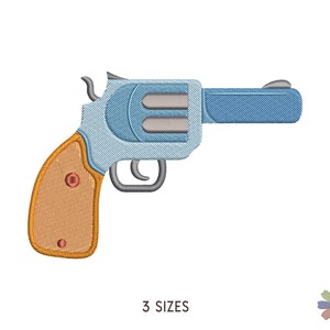 May include: Embroidered design of a revolver gun in shades of blue, tan, and gray. The gun features a detailed handle and barrel, with the text "3 SIZES" below. A floral design is in the lower right corner.
