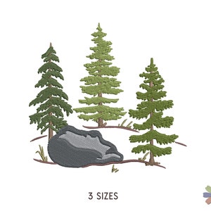 Puede incluir: Diseño bordado de tres pinos verdes y una gran roca gris. Los árboles están estilizados y tienen un diseño simple. La roca está en el centro del diseño y es ligeramente redondeada.