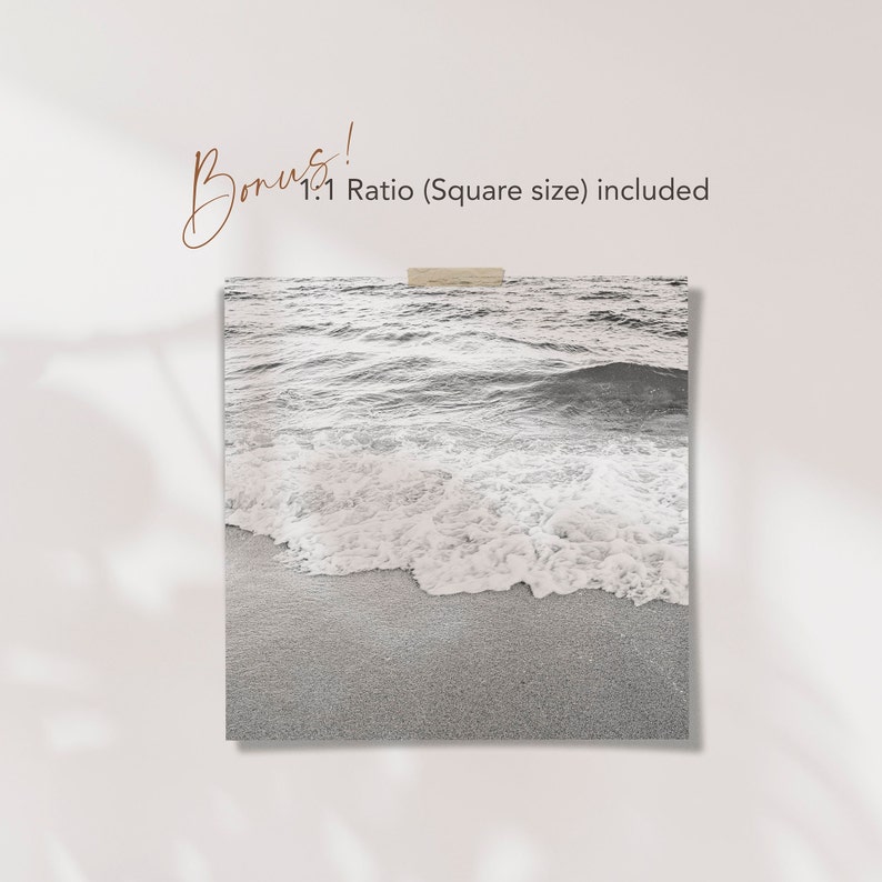 May include: A black and white photograph of ocean waves crashing on a sandy beach. The image is a close-up of the waves and the sand.