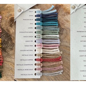 May include: A color chart of 18 different colors of cord, with each color labeled. The colors include: Milky Green, Dusty Pink, Pastel Pink, Mauve, Blush, Blossom, Mustard, Spicy Yellow, Caramel, Terracotta, Sunset, Wild Rose, Avocado, Pine Green, Misty, Jeans, Peacock Blue, Teal, Laurel, Eucalyptus Green, Magic Green, Magic Iris, Magic Pink, Golden Natural, Metallic Gold, Metallic Copper, Metallic Champagne, Metallic Rose Gold, Metallic Silver, Coffee, Sand, Pearl, Beige, Nude, Rainbow Dust, Natural, Off White, White, Moonlight, Light Grey, Silver, Steel, Charcoal, and Black.