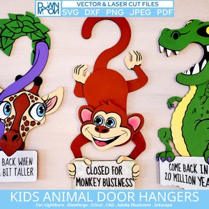 Puede incluir: Tres percheros de puerta de animales de madera con un gancho en la parte superior. Los percheros son una jirafa, un mono y un dinosaurio. La jirafa es marrón y amarilla con un cuello morado y hojas verdes en la cabeza. El mono es marrón con una cara amarilla y un cartel que dice "Cerrado por asuntos de mono". El dinosaurio es verde con una barriga amarilla y un cartel que dice "Vuelve en 20 millones de años".