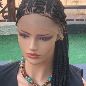 May include: A black braided wig with a lace front. The wig is styled in a box braid pattern with the braids extending down the back of the wig. The wig is on a mannequin head with a necklace.