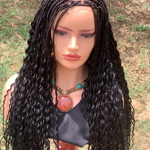 May include: A long, black wig with small braids and loose curls. The wig is styled with a middle part and has a lace front.