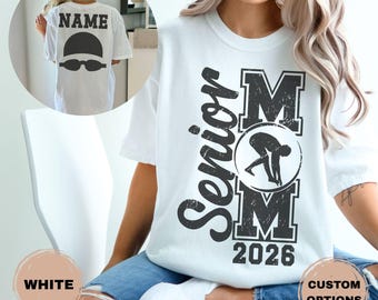 Peut inclure: T-shirt blanc avec un motif noir. Le devant affiche "Senior Mom 2026" avec une illustration de nageur. Le dos montre un bonnet et des lunettes de natation avec le mot "NAME" au-dessus. Options personnalisées disponibles.