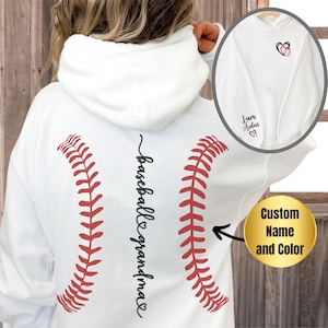 May include: White hooded sweatshirt with a red baseball stitch design and the text "baseball grandma" on the back. The sweatshirt is customisable with a name and colour.