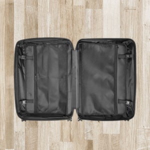 May include: An open black suitcase with multiple compartments and zippered pockets. The suitcase is empty and ready for packing.