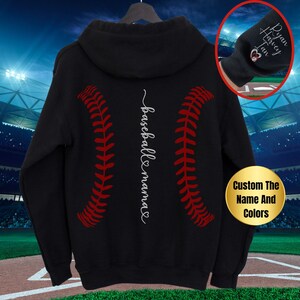 May include: Black hooded sweatshirt with a baseball stitch design and the text "baseball mama" in white. The sweatshirt is customizable with a name and colors.