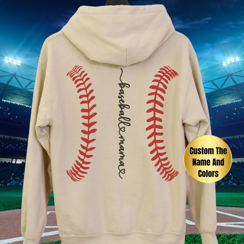 May include: A beige hoodie with a baseball graphic and the text "baseball mama" on the back. The baseball graphic is red and white.