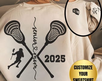 May include: A beige sweatshirt with a lacrosse stick design and the text "Senior Mom 2025". The sweatshirt has a customizable option.