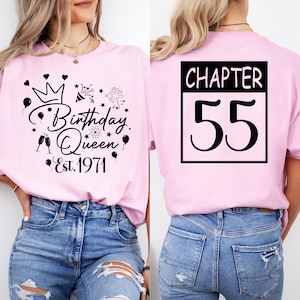 May include: Pink t-shirt with black graphic text and illustrations. The front says "Birthday Queen Est. 1971" with a crown, balloons, and fireworks. The back says "Chapter 55" in a black box.