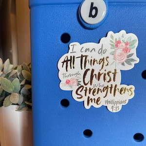 May include: A blue plastic container with a white sticker that says "I can do all things through Christ who strengthens me Philippians 4:13". The sticker has pink flowers and gold lettering.