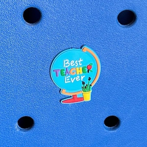 May include: A blue globe with the text "Best Teacher Ever" in rainbow colours. The globe has a red base and a green pot with yellow flowers.