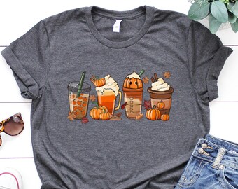May include: A dark gray t-shirt with a graphic of four fall-themed drinks with pumpkin accents. The drinks include a pumpkin spice latte, a pumpkin beer, a pumpkin smoothie, and a pumpkin iced coffee.