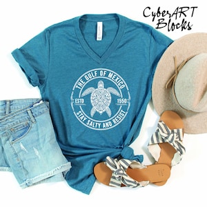 a blue shirt with a turtle on it and a hat next to it