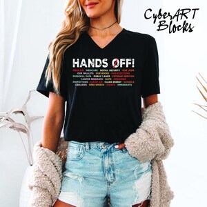 a woman wearing a black shirt with the words hands off on it