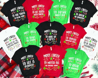 May include: A set of ten Christmas-themed t-shirts with different humorous sayings. The shirts are in various colors, including red, green, black, and white. The sayings on the shirts include "Most Likely to Ask Santa to Define Good", "Most Likely to Get Sassy with Santa", "Most Likely to Drink Santa's Beer", "Most Likely to Break an Ornament", "Most Likely to Watch All the Christmas Movies", "Most Likely to Spike the Eggnog", "Most Likely to Wake Up First", "Most Likely to Spread Christmas Cheer", "Most Likely to Be Santa's Favorite", "Most Likely to Hit a Reindeer", "Most Likely to Watch All the Football Games", and "Most Likely to Break an Ornament".
