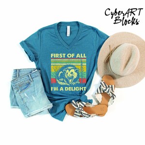 a blue shirt with a lion on it next to a hat