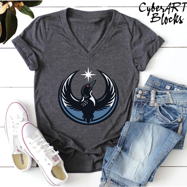 a gray v-neck t-shirt with a graphic design, a pair of white sneakers, and a pair of blue jeans laid out on a white surface.
