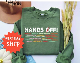 May include: Green sweatshirt with the text "HANDS OFF!" and a list of items including "Medicaid", "Medicare", "Social Security", "Our Wallets", "Our Books", "Fair Elections", "Personal Data", "Public Lands", "Cancer Research", "NATO", "Consumer Protections", "Clean Air", "Clean Energy", "Libraries", "Free Speech", "Courts", and "Immigrants".