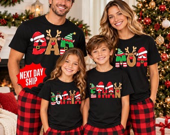 May include: Black short-sleeve t-shirts featuring colorful Christmas-themed lettering. The designs include Santa hats, reindeer antlers, and elf caps integrated into the letters spelling out names like DAD, MOM, SOPHIA, and ETHAN.