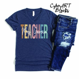 a t - shirt that says teacher next to a pair of jeans