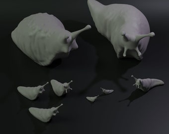 May include: A group of seven gray ceramic slugs of varying sizes. The slugs are arranged on a black surface. The largest slug is in the center of the image, with the smaller slugs arranged around it.