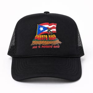 Puede incluir: Gorra de camionero negra con la bandera de Puerto Rico y el texto "PUERTO RICO" y "100% PUERTO RICO". El diseño de la bandera incluye una estrella blanca sobre un triángulo azul y rayas rojas y blancas.