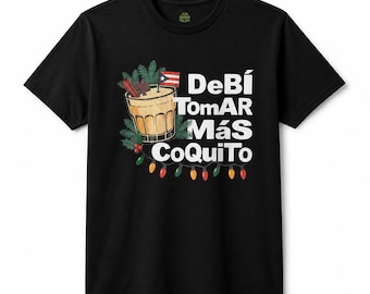 May include: A black short-sleeve t-shirt featuring a graphic of a glass of coquito garnished with cinnamon sticks and a Puerto Rican flag. The text reads "DeBí ToMAR MÁS CoQuiTo" in white letters, accented by green pine branches and colorful holiday lights.