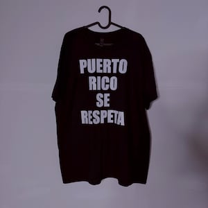 Könnte beinhalten: Schwarzes T-Shirt mit weißem Text, der "PUERTO RICO SE RESPETA" lautet.